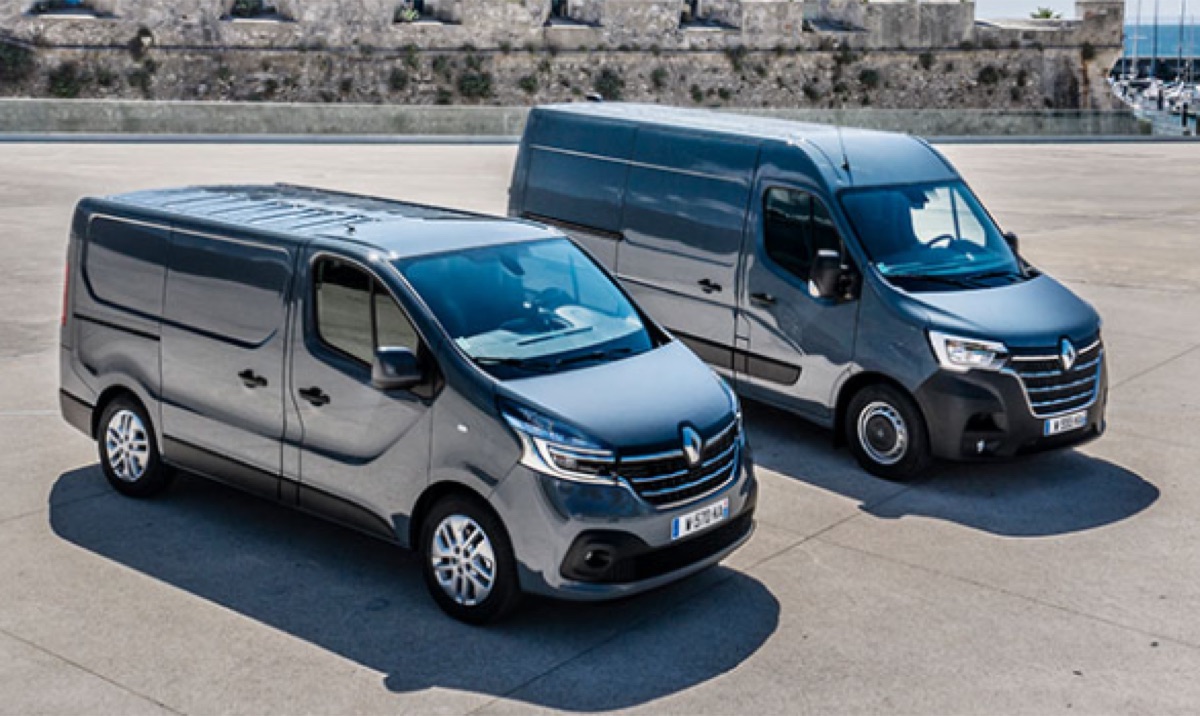 Two grey electric light-commercial vans parked side by side on a waterfront lot
