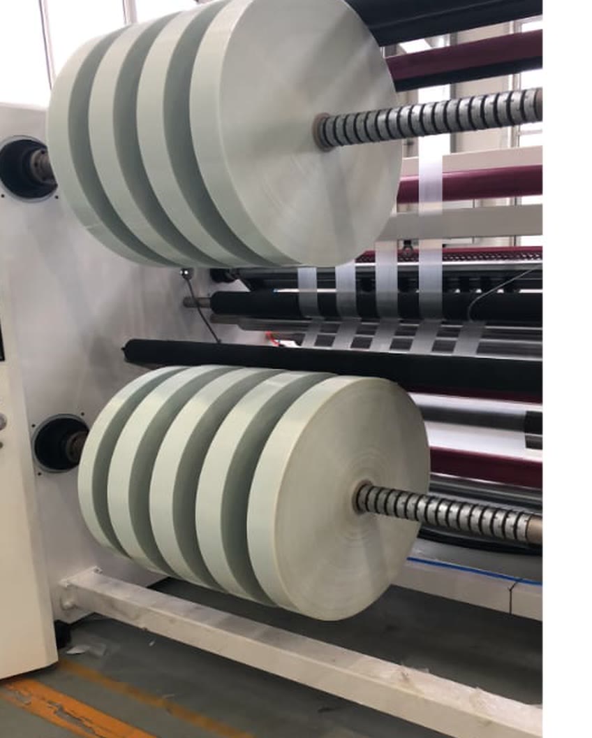 Narrow slit tape rolls stacked on the shaft of a slitting machine