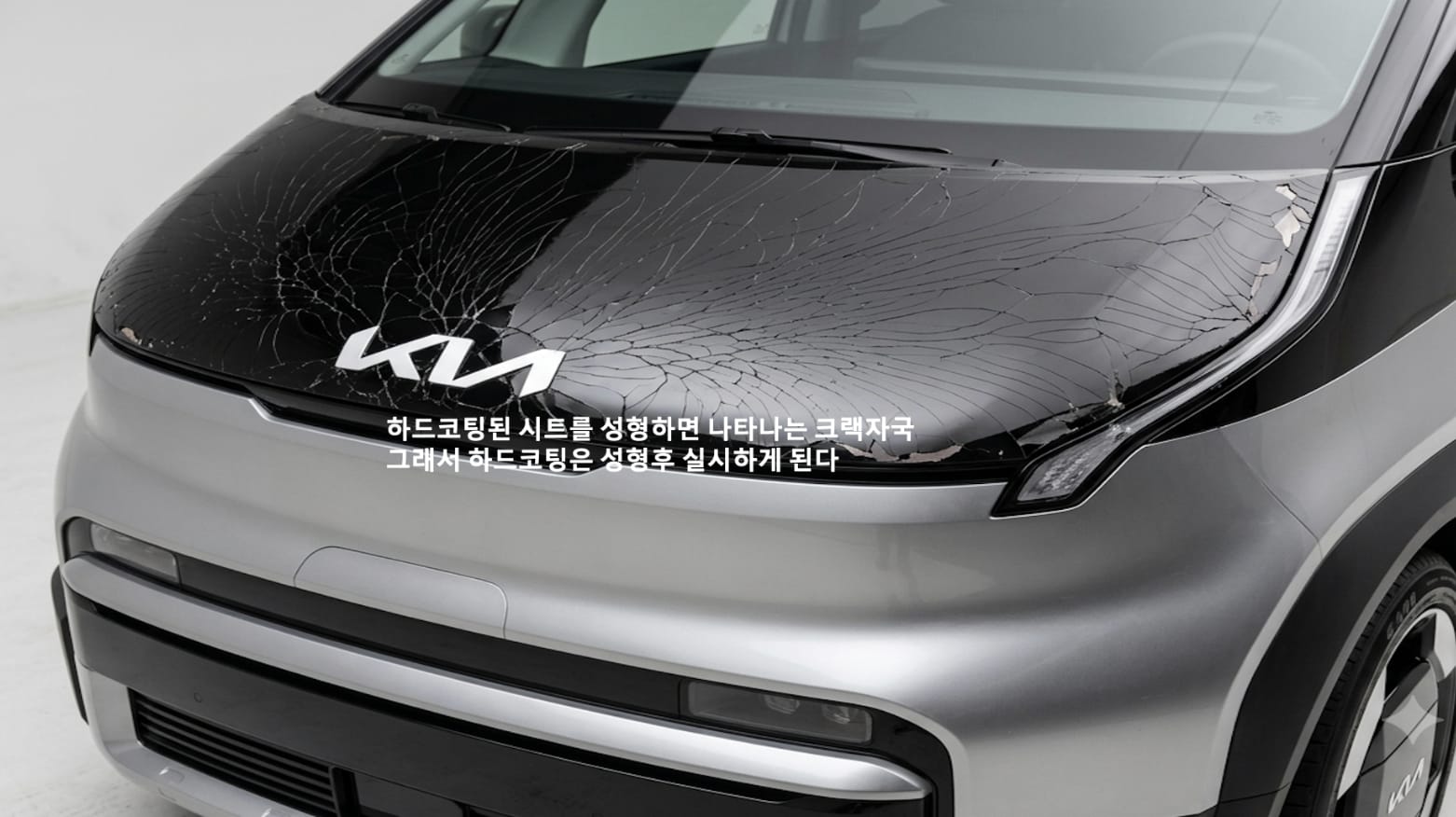 A high-gloss black bonnet covered in a dense web of fine cracks across its whole surface