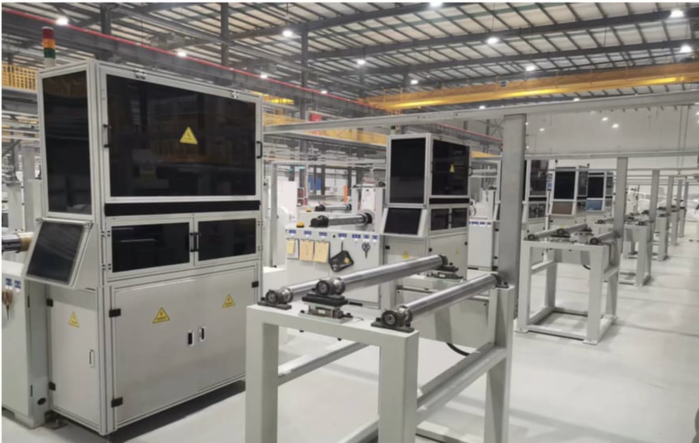 Inline vision-inspection cells with industrial cameras mounted over a running tape line