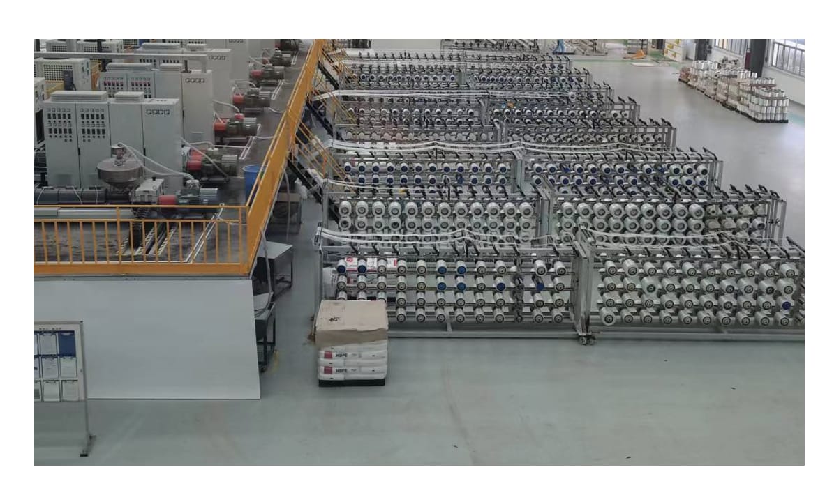 Several finished rolls of unidirectional glass-fibre tape standing on a plant floor